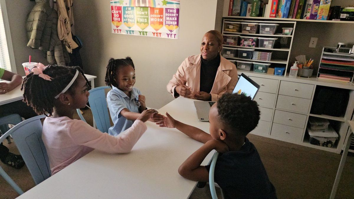 Guide working with young K-2 scholars at a small table